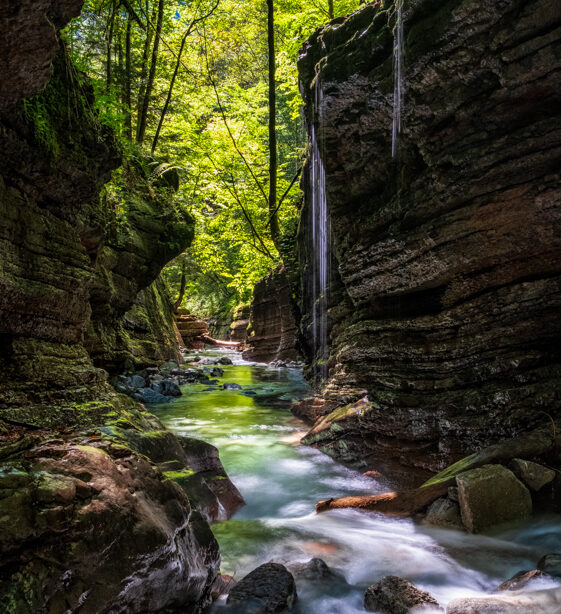 Wasserlauf durch Felsen bei schönem Sonneneinfall und Tropfen